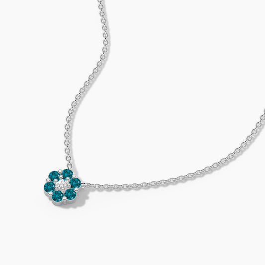 Silver necklace with a flower-shaped pendant featuring blue stones on a white background