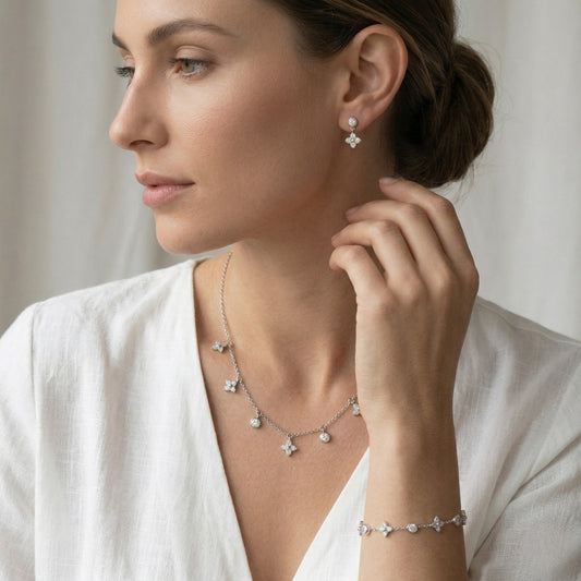 Woman wearing a silver necklace, earrings, and bracelet