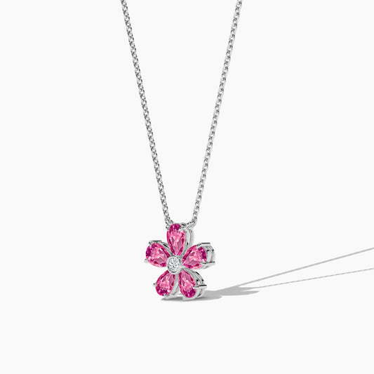 Flower-shaped pink gemstone pendant on a silver chain against a white background