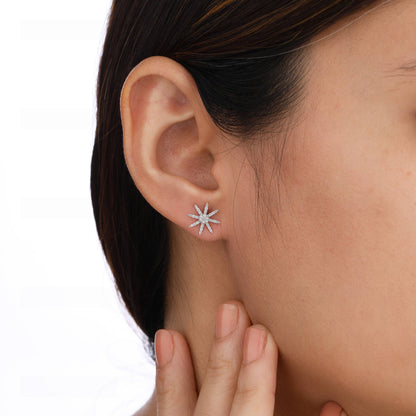 Close-up of a person wearing a star-shaped silver earring 