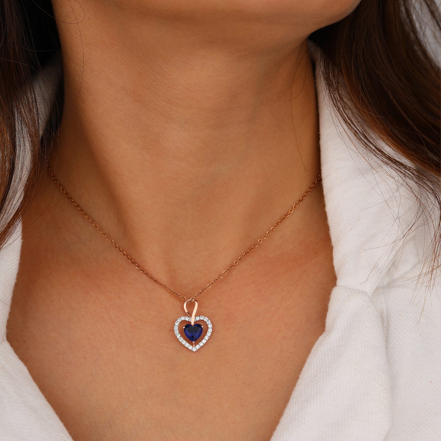 Necklace with a heart-shaped pendant featuring a blue gemstone 