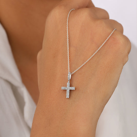 Silver cross necklace on a hand 
