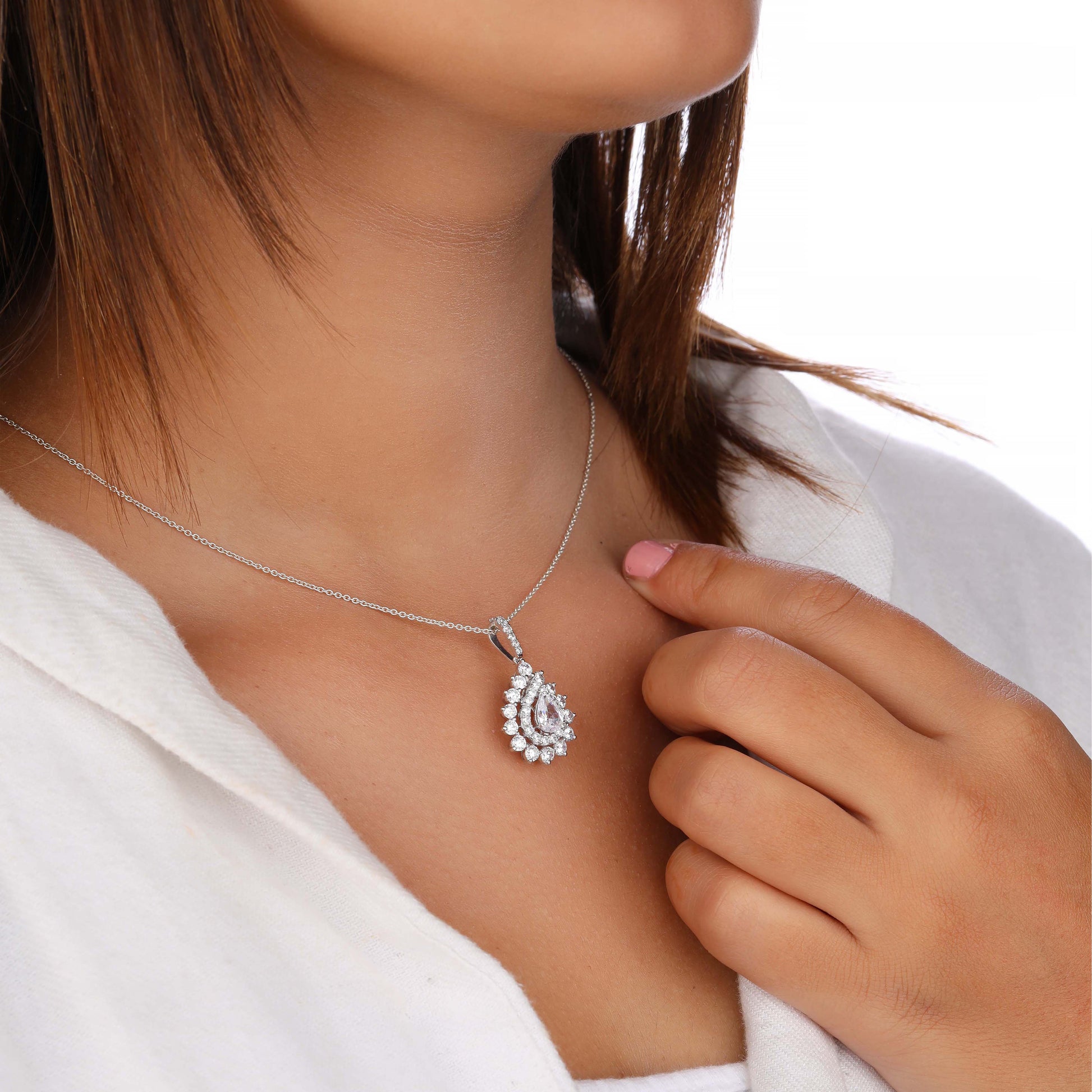 Silver necklace with a teardrop-shaped pendant worn by a person