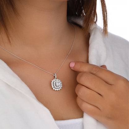 Person wearing a silver necklace with a round pendant