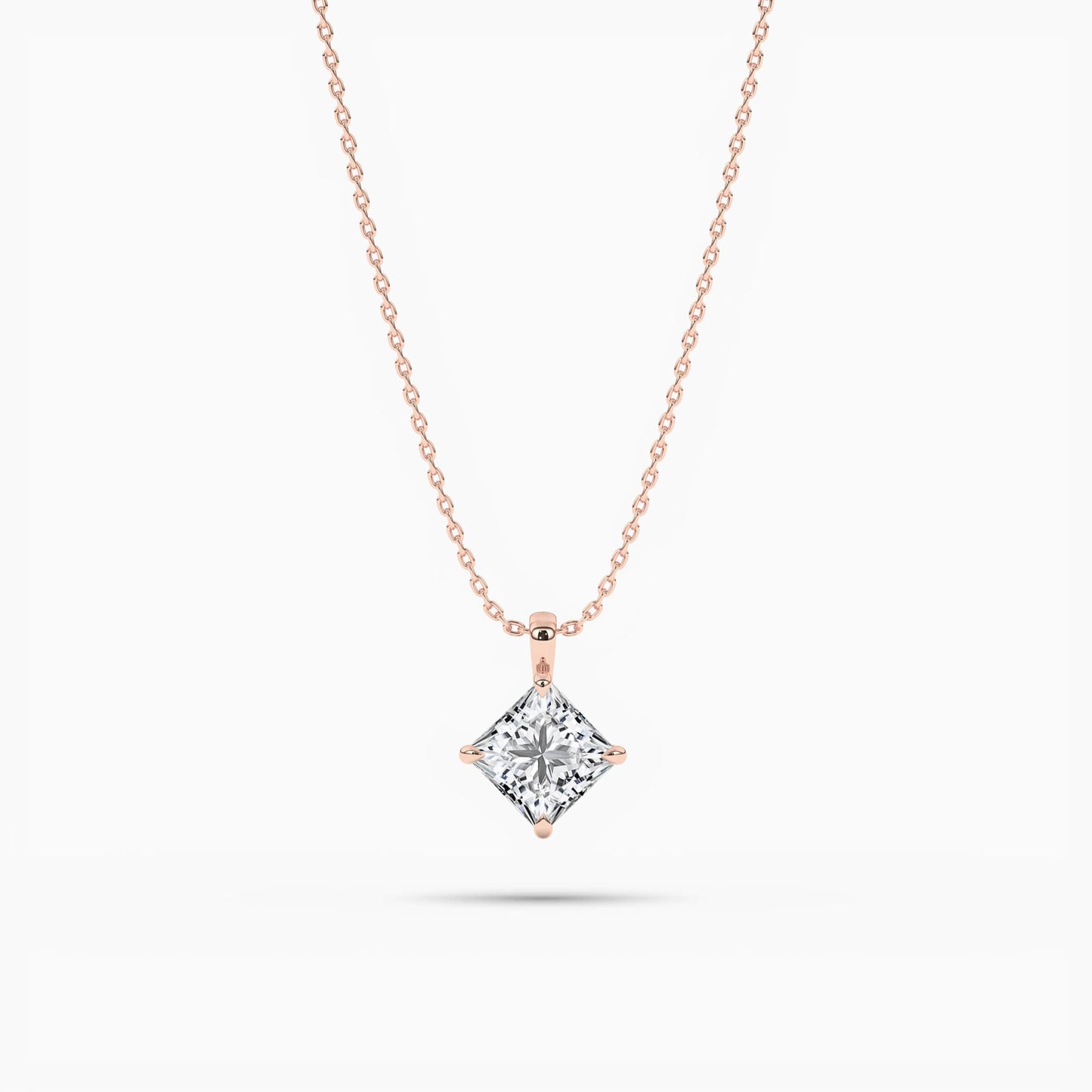 Rose gold necklace with a diamond pendant on a white background