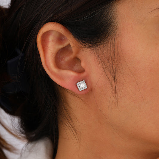 Close-up of an ear wearing a square diamond earring.