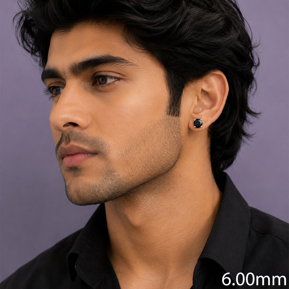 A close-up side profile of a man wearing a small black stud earring 