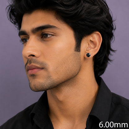 A close-up side profile of a man wearing a small black stud earring 