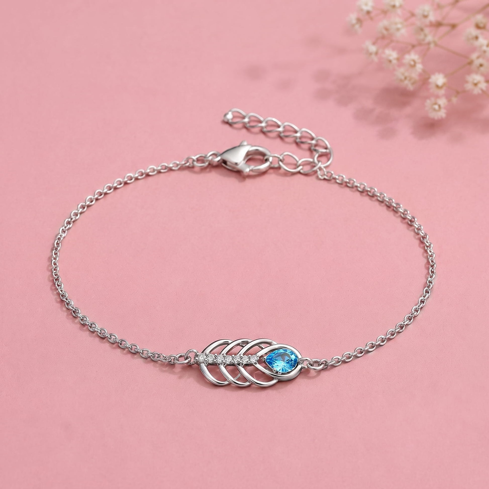 Silver chain bracelet with a central leaf-like motif and a bright blue oval stone
