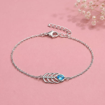 Silver chain bracelet with a central leaf-like motif and a bright blue oval stone