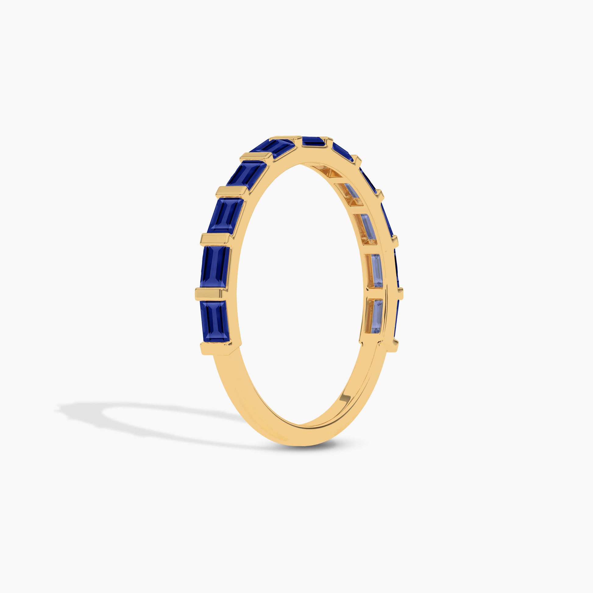 Gold plated ring with blue gemstones on a white background