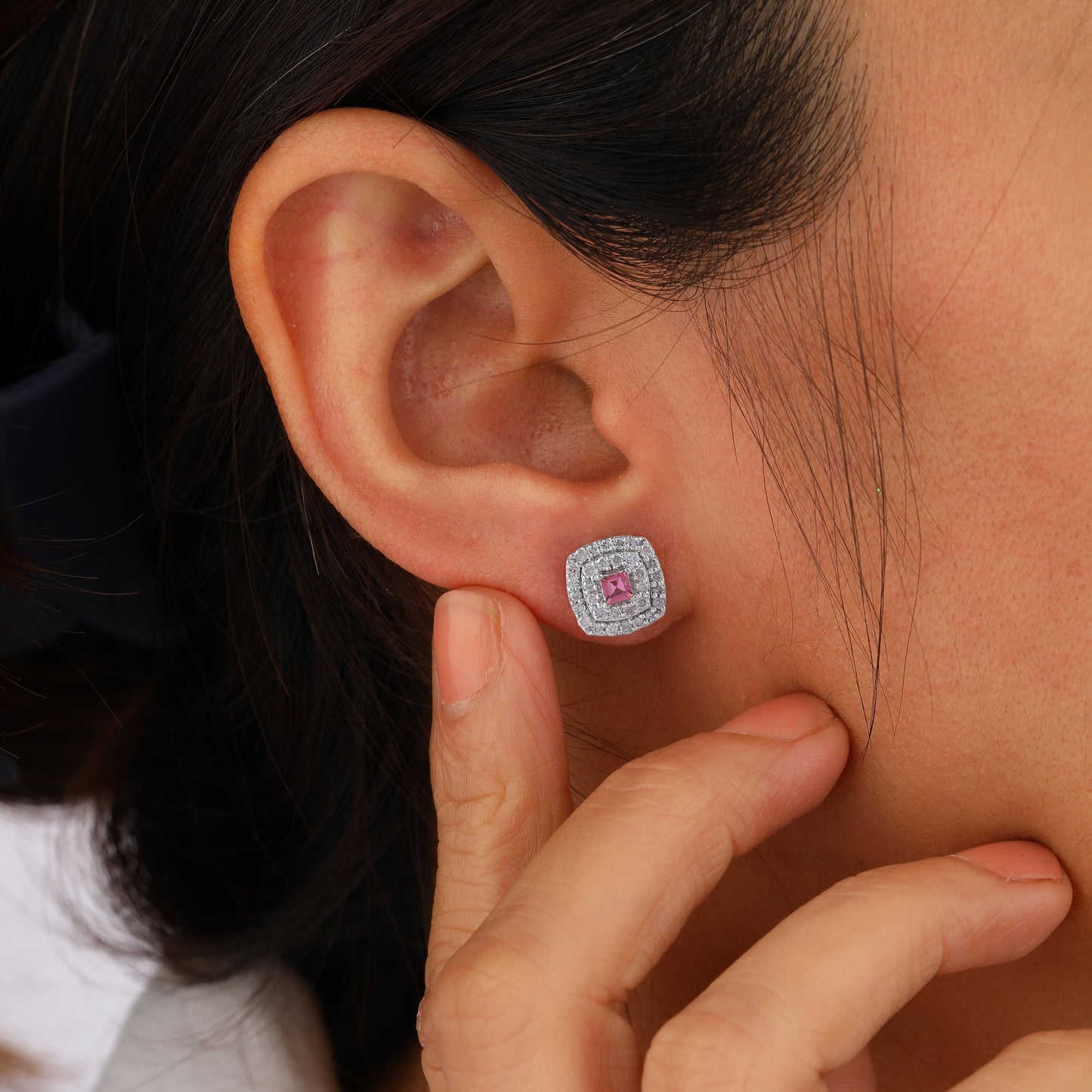 square-shaped earring with a pink gemstone.
