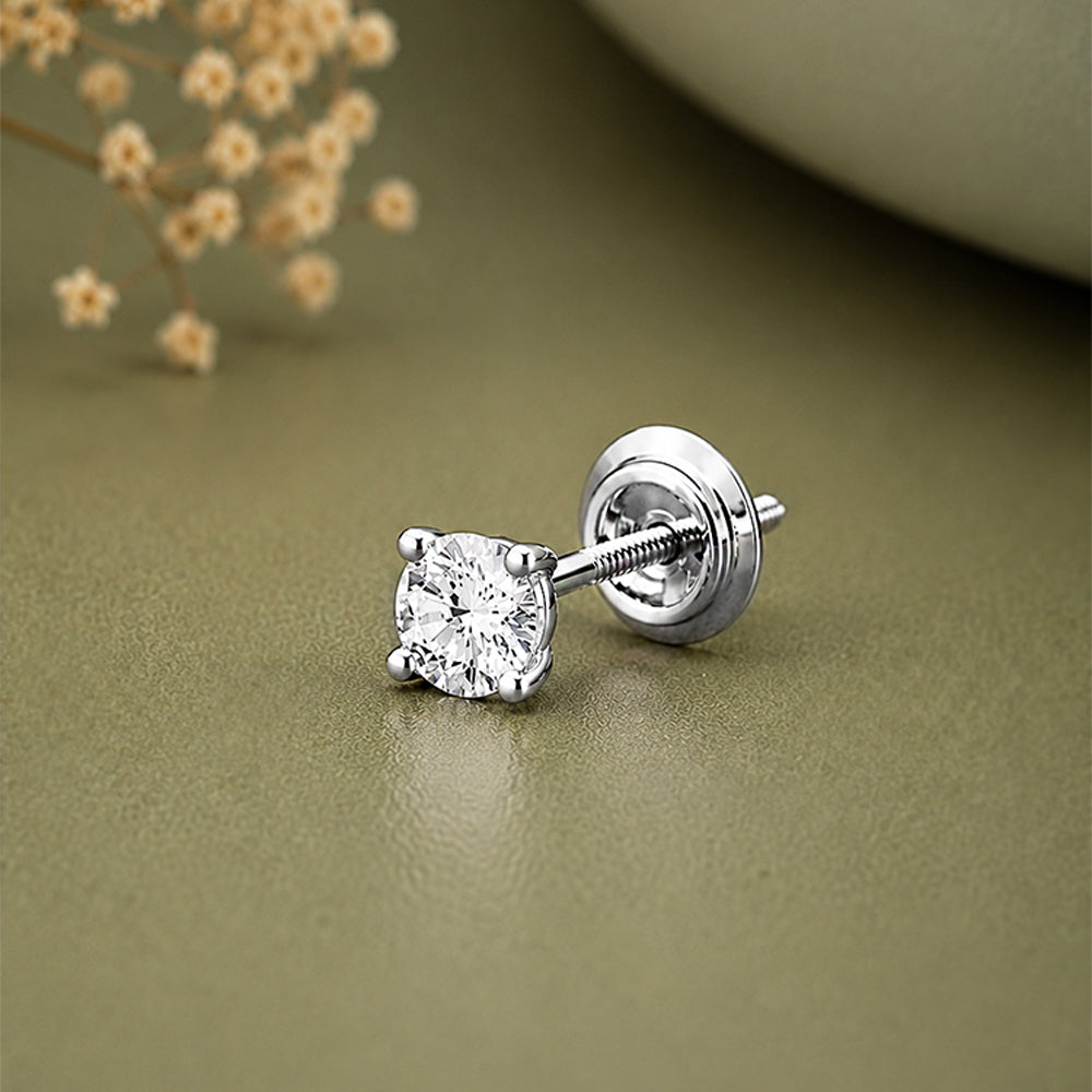 A single silver stud earring with a round clear gemstone in a four-prong setting