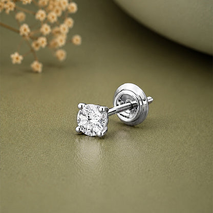 A single silver stud earring with a round clear gemstone in a four-prong setting
