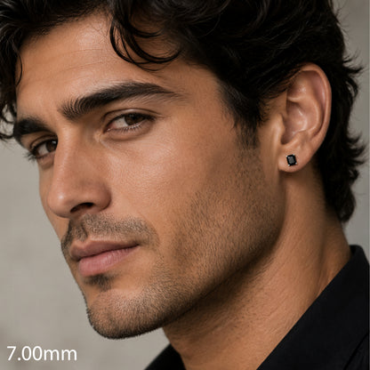 Close-up of a man wearing a black earring with a gray background