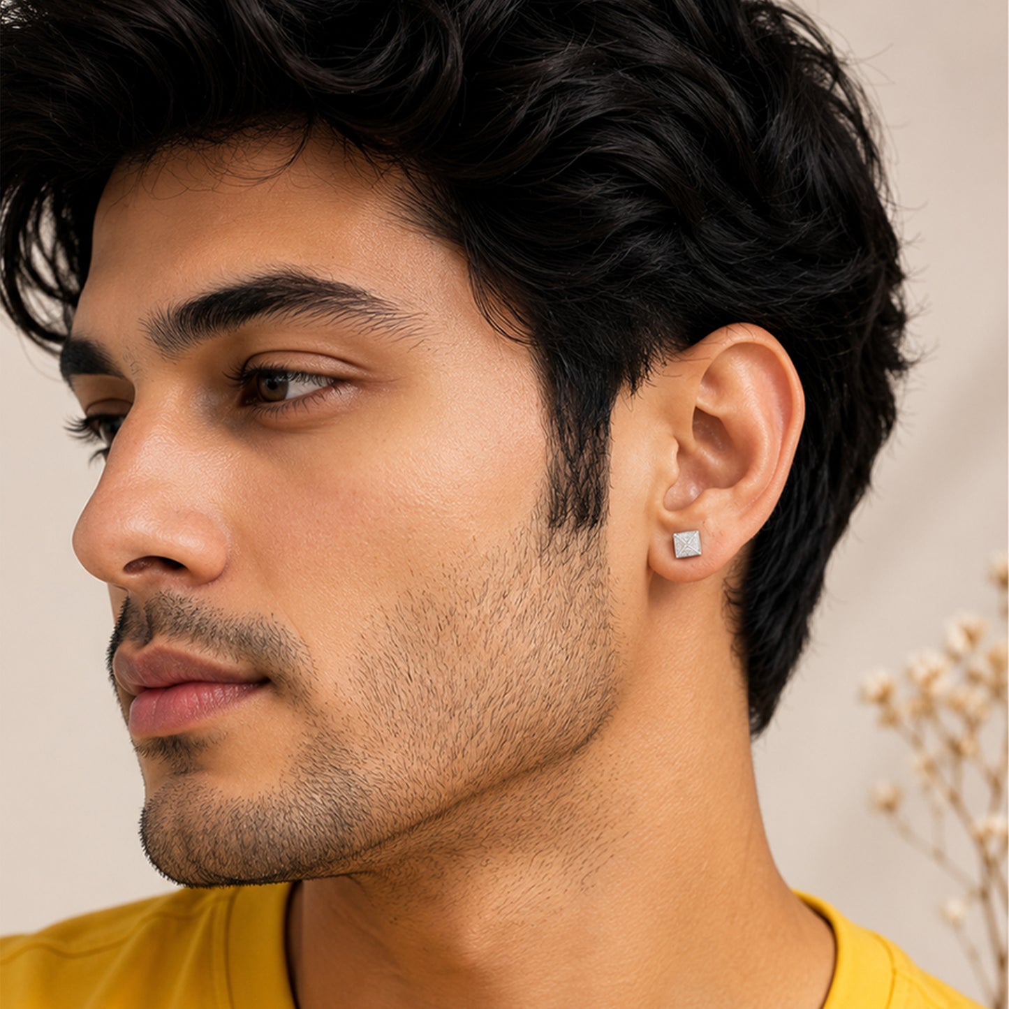 Close-up of a man wearing a square earring 