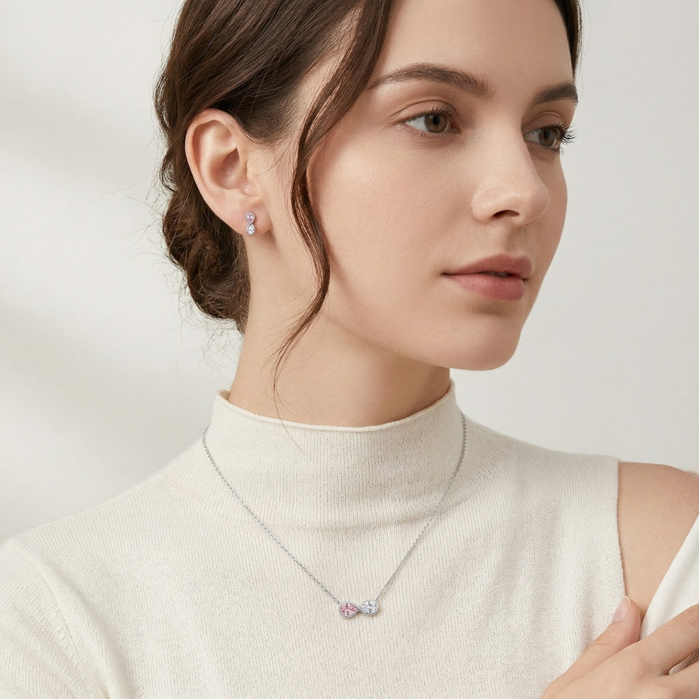 Woman wearing a necklace and earrings on a plain background