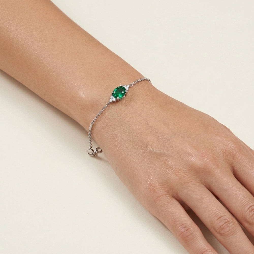 Bracelet with a green gemstone on a wrist 
