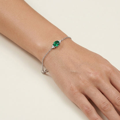 Bracelet with a green gemstone on a wrist 