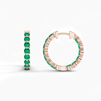 Rose gold hoop earrings with green gemstones on a white background