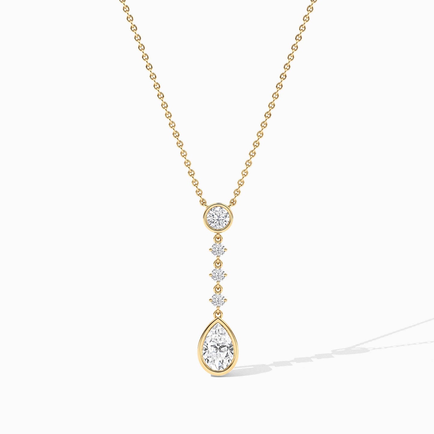 Gold necklace with a teardrop-shaped pendant on a white background