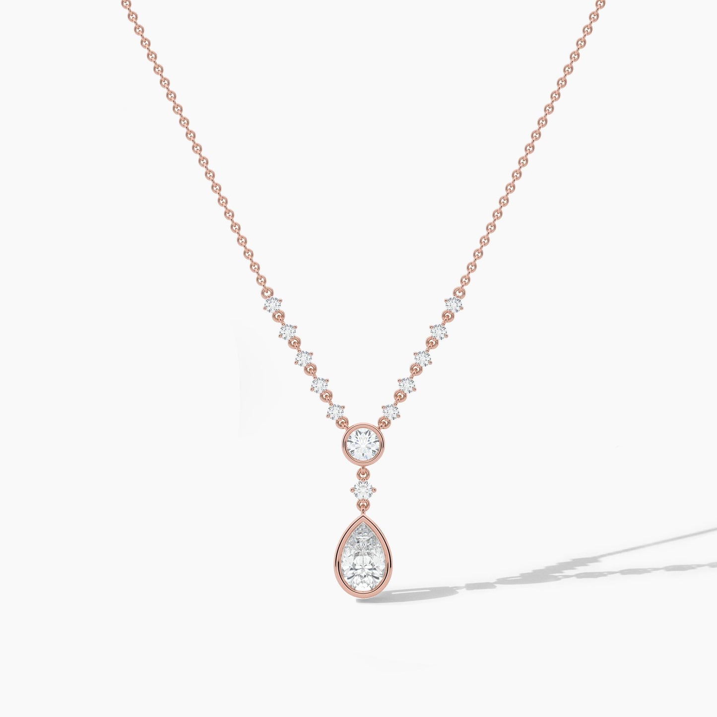 Rose gold necklace with a teardrop-shaped pendant on a light gray background