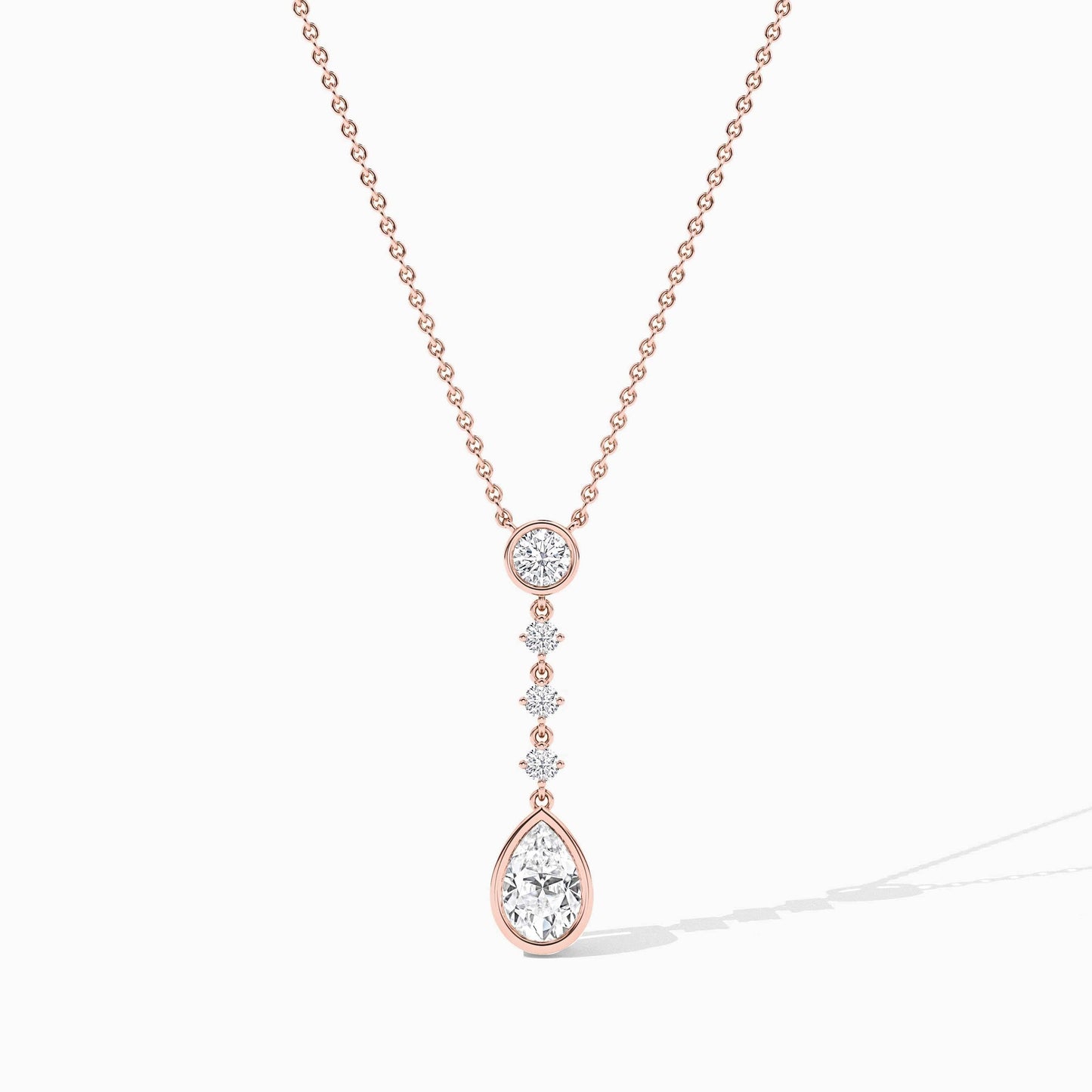 Rose gold necklace with a teardrop pendant on a white background