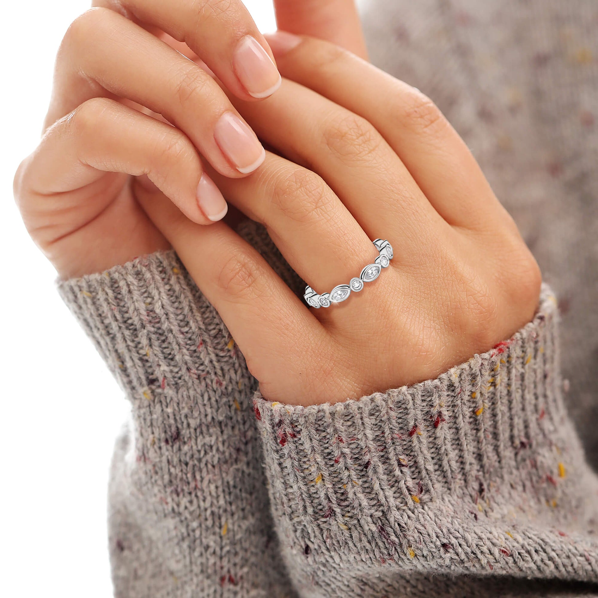 Close-up of a hand wearing a silver ring with small 