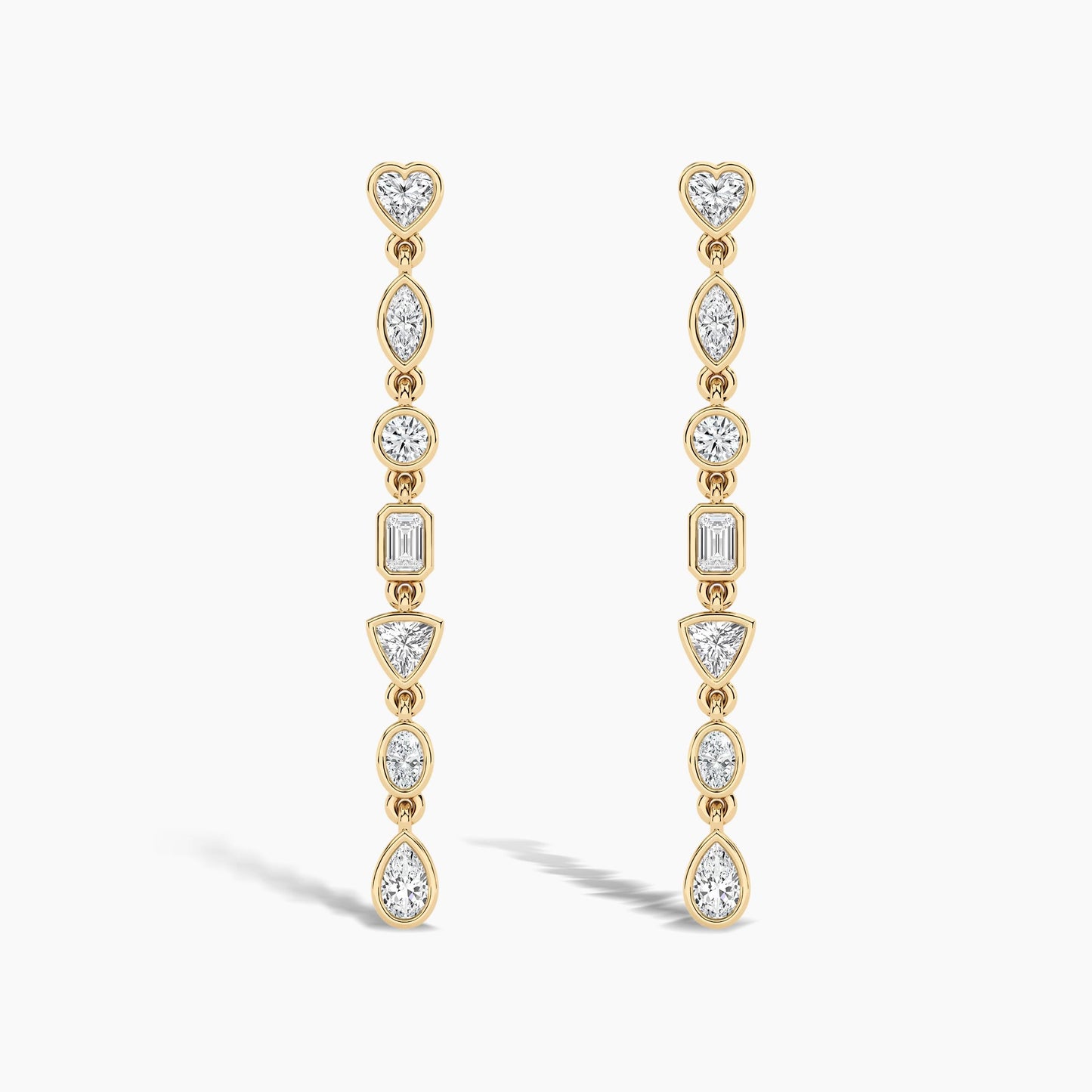 Gold earrings with clear gemstones on a white background