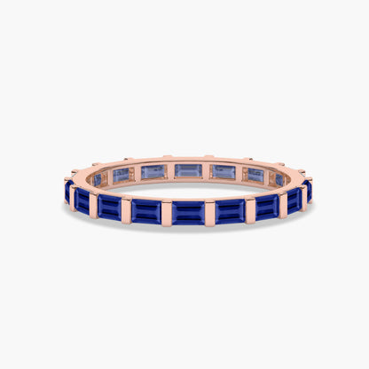Rose gold-plated ring with blue gemstones on a white background