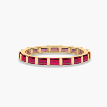 Gold ring with red gemstones on a white background